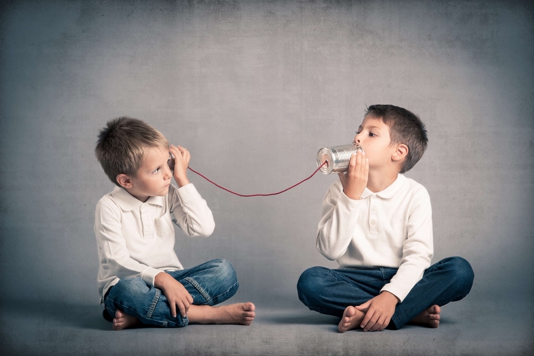2 boys talking using 2 cans and a string